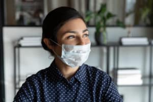 A woman in the workplace wearing a protective mask against COVID-19